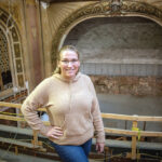 IN PROGRESS: Melissa Quinn, managing director of the Newport Performing Arts Center, says restoration work on the decorative plaster around the proscenium arch that frames the stage behind her is still needed as part of renovating the former Opera House Theater to become the center’s new home. PBN PHOTO/DAVID HANSEN