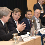 HELP NEEDED: Dr. Michael Wagner, left, CEO and president of Care New England Health System, discusses the health services industry in Rhode Island, including workforce development, with other panelists at Providence Business News’ Fall 2023 Health Care Summit on Oct. 25. Others on the panel include, from left, Brown University’s Dr. Scott Rivkees, Dr. Raj Hazarika from Point32Health Inc. and John Fernandez, CEO and president of Lifespan Corp. Moderating is PBN Editor Michael Mello, standing.  PBN PHOTO/MIKE SKORSKI