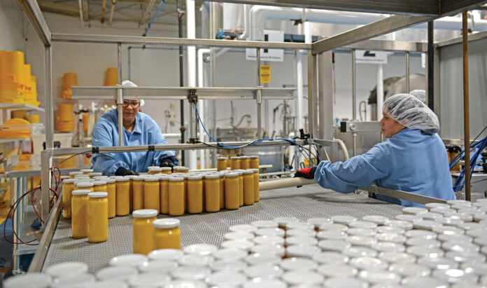 BOTTLED UP: Employees at Plants to Food LLC in Lincoln operate machinery that bottles products such as pasta sauces.
PBN PHOTO/ELIZABETH GRAHAM BOTTLED UP: Employees at Plants to Food LLC in Lincoln operate machinery that bottles products such as pasta sauces.
PBN PHOTO/ELIZABETH GRAHAM