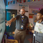 CLASS PREPARATION: William M. Davies Jr. Career and Technical High School English teacher Dina Louis, right, and social studies teacher Ryan Hall go over a lesson plan in a classroom at the Lincoln-based school. PBN PHOTO/RUPERT WHITELEY