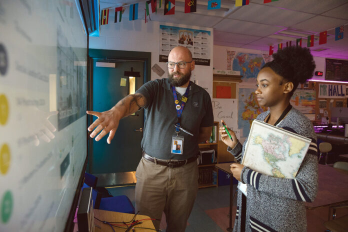 CLASS PREPARATION: William M. Davies Jr. Career and Technical High School English teacher Dina Louis, right, and social studies teacher Ryan Hall go over a lesson plan in a classroom at the Lincoln-based school. PBN PHOTO/RUPERT WHITELEY