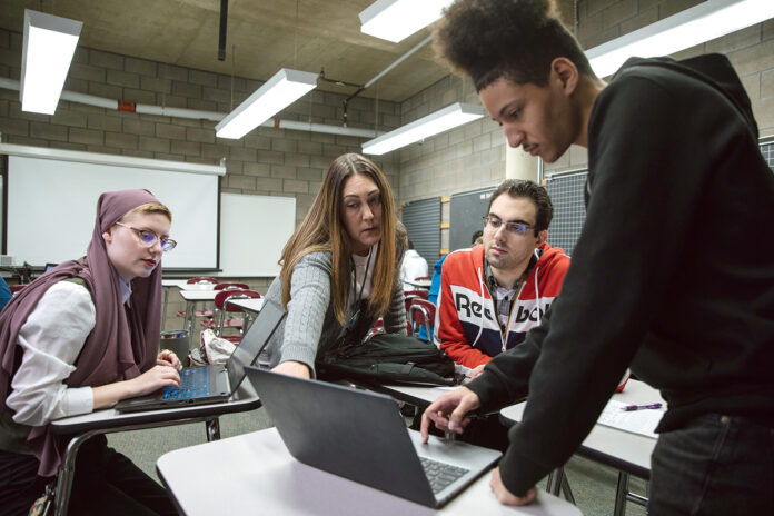 OFFERING GUIDANCE: Community College of Rhode Island professor Alyson Snowe, second from left, talks with her technical writing students, from left, Iskandar Miley, Kenneth Hanner and Bryan Pichardo. PBN PHOTO/RUPERT WHITELEY