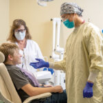 OPEN UP: Dentist Milton J. Liu, right, and dental assistant Lori Beth Adler prepare to examine the teeth of patient Anthony Northup at Wood River Health in Hopkinton.  COURTESY WOOD RIVER HEALTH
