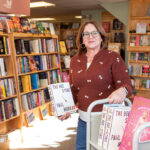 TURNING THE PAGE: Laurie Sutherland says she always wanted to own her own bookstore, so when she saw an online ­advertisement for the sale of Island Books in Middletown, she visited the store, fell in love with it and bought the store.  PBN PHOTO/DAVID HANSEN