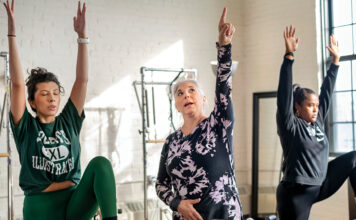 REACHING FOR THE SKY: Mind 2 Body Fitness owner Maria ­Andresino, center, instructs Nicole Gonzalez, left, of Cumberland and Analy Lopes of East Providence during a Pilates class at her Providence studio. PBN PHOTO/MICHAEL SALERNO