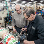 GOING STRONG:  John Vitko, left, customer service, and assembly worker George Durfee are part of an older workforce that manufacturer VIBCO Inc. continues to rely heavily on, according to CEO Karl ­Wadensten.  PBN PHOTO/ TRACY JENKINS
