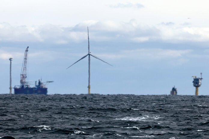 ON THE HORIZON: Ships get into position in December to finish building turbines for South Fork Wind, 15 miles east of Block Island. The wind farm is now operational and providing power for New York.  AP FILE PHOTO/JULIA NIKHINSON