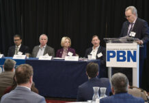 DOWN TO A SCIENCE: Neil D. Steinberg, second from right, chair of the R.I. Life Sciences Hub, speaks during a panel discussion on the state’s life sciences sector at Providence Business News’ 2024 ­Emerging Industries Summit at the Providence Marriott on March 13. Also on the panel are, from left, Dr. Gaurav Choudhary, medical director of Lifespan Corp.’s Cardiovascular Institute clinical trials office; Justin Fallon, Brown University professor and founder of biotech company Bolden Therapeutics Inc.; and Carol Malysz, executive director of RI Bio. PBN Editor Michael Mello, standing at right, moderates. PBN PHOTO/MIKE SKORSKI