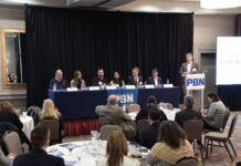 JIM OWENS, second from left, Nautilus Defense LLC principal, speaks during one of two panel discussions at Providence Business News' Emerging Industries Summit at the Providence Marriott on Wednesday. Also on the panel is, from left, Anthony Baro, E2SOL LLC managing principal; Jeanine Boyle, Inspire Environmental Inc. CEO; Nishita Roy-Pope, Tribe Academy LLC founder and CEO; Marc Parlange, University of Rhode Island president; Stephen Piper, lead client partner, state of Rhode Island, IBM Consulting. URI Research Foundation Executive Director Christian Cowan, standing at right, was the moderator. / PBN PHOTO/MIKE SKORSKI