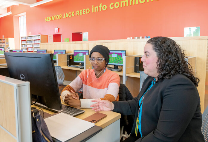 TECH TALK: Lina Bravo, right, digital equity and learning coordinator at the Providence Public Library, assists Wathira Nganga, who is visiting Providence from New Jersey, at one of the library’s computer stations. PBN PHOTO/­MICHAEL SALERNO