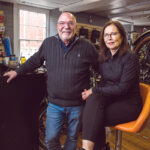 SOARING SALES: Co-owner Mark DeFestano says sales exploded at Bristol Bikes LLC, which specializes in electric bicycles, following the COVID-19 pandemic shutdowns and he anticipates continued demand now that it will take years to repair the Washington Bridge in Providence, which was partially closed in December due to an infrastructure failure. DeFestano is pictured with his wife and co-owner, Robin Paradis. PBN PHOTO/RUPERT WHITELEY