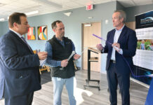 SEEING THE LIGHT: During a recent visit to Ortho Rhode Island in Warwick, Mike Mogul, right, IlluminOss Medical Inc. board chairman, explains to House Speaker K. Joseph Shekarchi, left, how the company’s technology works to mend bones through the use of light-sensitive glue and blue optic fibers. In the middle is Ortho RI CEO and President Dr. Michael Bradley.  PBN PHOTO/KATIE CASTELLANI