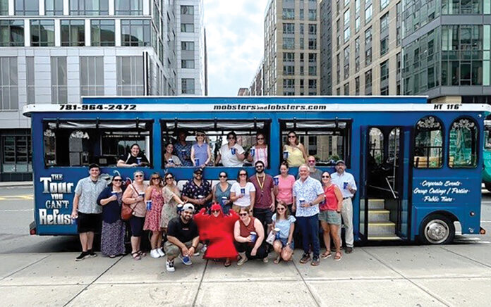 ON TOUR: Healthcentric Advisors gather in front of a Mobsters and Lobsters tour bus outside of Boston.  COURTESY HEALTHCENTRIC ADVISORS