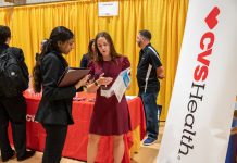 LINDSAY WALSA, center, of CVS Health Corp., speaks with a Bryant University student during the university's Career Fair back in September. Bryant officials feel the university does more than enough to prepare students for life after graduation and does not need to implement a "job guarantee" program similar to what Curry College in Milton, Mass., is launching. / COURTESY BRYANT UNIVERSITY/PAM MURRAY