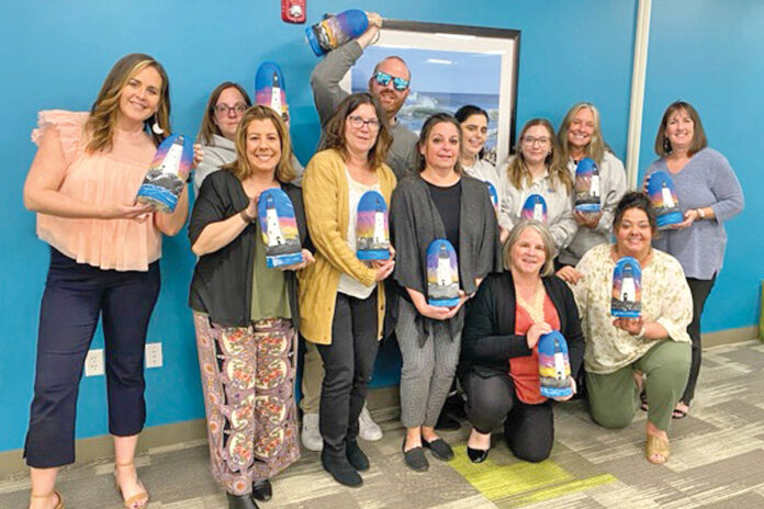 PAINT JOB: Employees for Westerly Community Credit Union hold up paintings they made during a recent company Paint Night.  COURTESY WESTERLY COMMUNITY CREDIT UNION