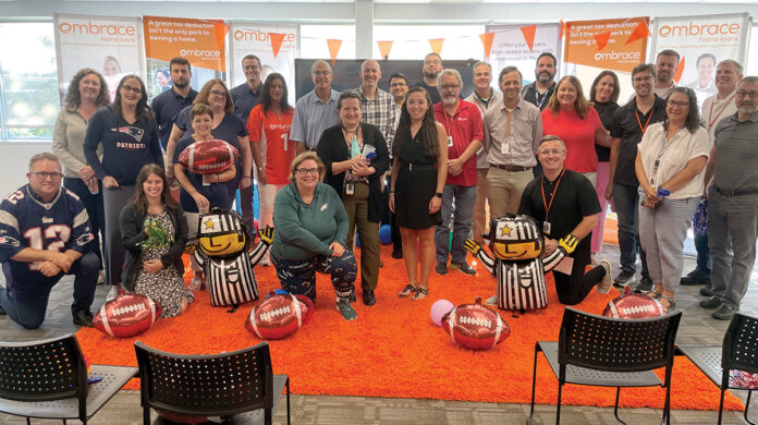GAME TIME: Employees at Embrace Home Loans Inc. hold a football tailgate party at the office.  COURTESY EMBRACE HOME LOANS INC.