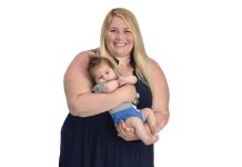 Kristen Botelho Pires the prop
Kristen Botelho Pires holds her infant son, Beau, while surrounded by a globe, AAA toys, a 10-key machine, a box, and New England Patriots and New England Revolution merchandise, signifying her life and career path.