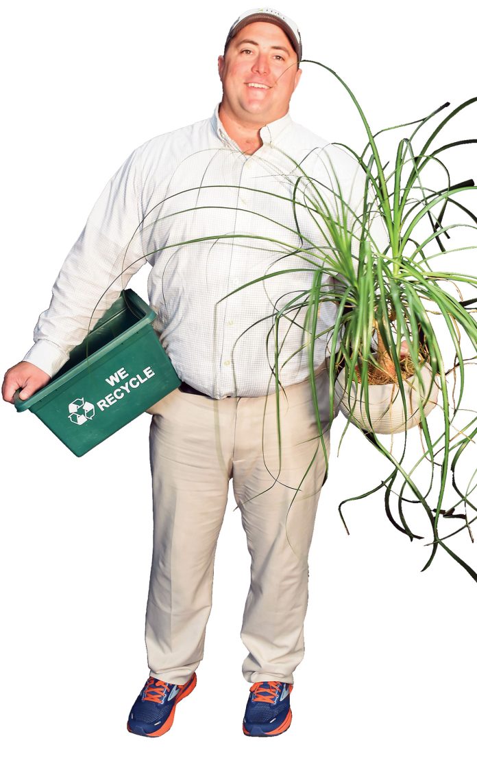 the prop Matthew A. Fannon poses with a plant from his office and a recycling bin, representing the different recycling streams that have been established on the Johnson & Wales University campus. the prop Matthew A. Fannon poses with a plant from his office and a recycling bin, representing the different recycling streams that have been established on the Johnson & Wales University campus.
