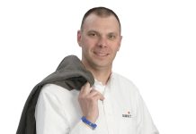                 the                   prop  Will Galloway holds a construction hard hat, which symbolizes both the industry he works in and the “many hats” he wears as a construction professional.
