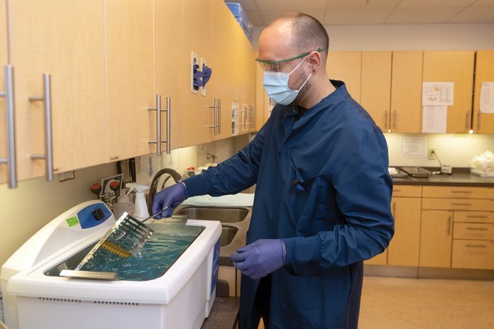 PREP WORK: Randall ­Bonilla sterilizes instruments for patient use at The Providence Community Health Centers Inc. PBN PHOTO/PAUL J. SPETRINI