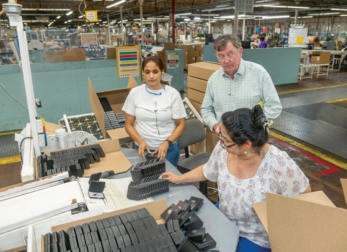 THE END RESULT: International Packaging Corp. CEO John Kilmartin, standing right, speaks with employees Vera Cruz, left, and Marybell Berdugo at a station where presentation boxes are packed for shipping.
PBN PHOTO/MICHAEL SALERNO THE END RESULT: International Packaging Corp. CEO John Kilmartin, standing right, speaks with employees Vera Cruz, left, and Marybell Berdugo at a station where presentation boxes are packed for shipping.
PBN PHOTO/MICHAEL SALERNO