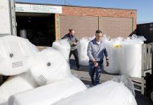 CLEAR PATH: From left, Atlantic Paper & Supply Operations Manager JC Lebarron and owner and Vice President David Spencer sift through multiple rolls of packaging paper at the company’s Pawtucket facility.  PBN PHOTO / TRACY JENKINS