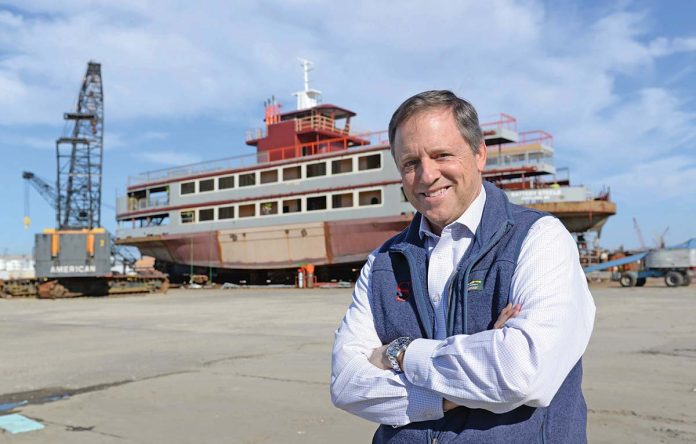 SHIPPING UP: Ted Williams, president of Senesco Marine LLC in North Kingstown, stands in front of a ferry that is under construction.  PBN PHOTO/ELIZABETH GRAHAM