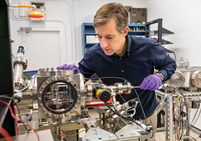 A BETTER WAY? Derek Stein, a Brown University physics professor and researcher, examines equipment that is used in a new mass spectrometry technique that makes the analysis of materials much more accurate and efficient. The technique developed at Brown could have far-reaching implications, including in areas of health care.  PBN PHOTO/MICHAEL SALERNO