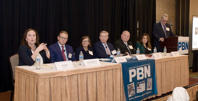 WHAT’S AHEAD? R.I. Commerce Secretary Elizabeth M. Tanner, far left, talks about what businesses can expect in the coming months during Providence Business News’ 2025 Economic Trends Summit on Jan. 30 at the Providence Marriott. With her on the panel, from left, are Leeds Mitchell IV, principal broker and partner at MG Commercial Real Estate Services Inc.; Sylvia Maxfield, interim provost and senior vice president for academic affairs at Providence College; Harold M. Horvat, Centreville Bank chairman, CEO and president; Edwin “Ted” Carr, Providence director of economic development; and Kristen Adamo, CEO and president of the Providence Warwick Convention & Visitors Bureau. PBN Editor Michael Mello, standing, moderates. PBN PHOTO/MIKE SKORSKI