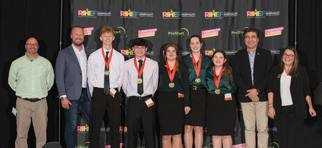 WINNING HOSPITALITY: Team Evergreen Lodge from the Chariho Area Career & Technical Center won first place in Hospitality Tourism Management as part of the 2025 Rhode Island ProStart High School Culinary Arts, Foodservice & Hotel Management Competition. Pictured from left are instructor Donald Fair; Rhode Island Hospitality Education Foundation Chairman Sam Glynn; students Morgan Allen, Gavin Apice, Juliet Costa, Molley Kennedy and Olivia Swanson; Farouk Rajab, CEO and president of the Rhode Island Hospitality Association; and Traci Dufresne, of the RIHA.
COURTESY RHODE ISLAND HOSPITALITY ASSOCIATION EDUCATION FOUNDATION