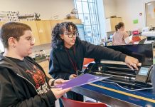 MAKER SPACE: ­Instructor Adaliz Rivera, above right, teaches Jasper Bliss, of Providence, how to operate a heat press and vinyl cutting machine in the first-floor workshop at Providence Public Library.  PBN PHOTO/­MICHAEL SALERNO