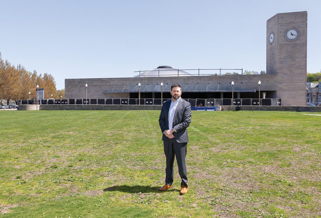 UNDER CONSIDERATION: R.I. Public Transit Authority CEO Christopher Durand stands in a field in front of the Providence train station, one of two parcels being considered for a new central transit hub.
PBN PHOTO/TRACY JENKINS