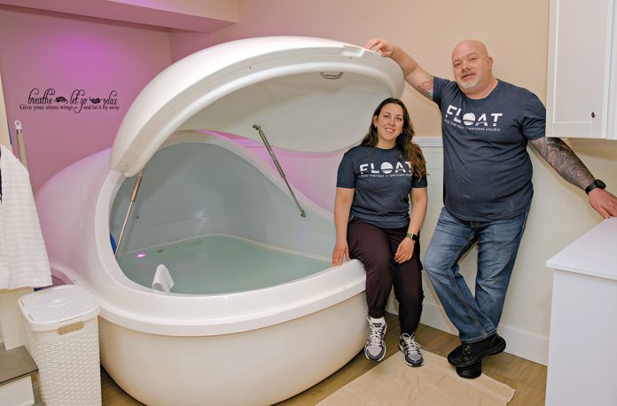 DEEP THERAPY: Float Rhode Island co-owners Lindy Fregeolle and Scott Mitchell with one of their float therapy pods, in which a person floats in a heated mixture of water and Epsom salts, which reduces or eliminates the senses so the mind and body can slow down and relax.  PBN PHOTO/MICHAEL SALERNO