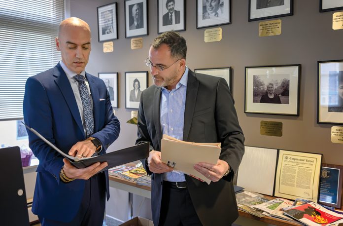 MAKING IT WORK: R.I. Public Defender Collin Geiselman, left, and Matthew Toro, deputy public defender, discuss cases in their office in Providence. Now that higher pay rates have been approved, the public defender’s office is having a much easier time keeping and hiring staff.  PBN PHOTO/­MICHAEL SALERNO