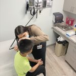 A CLOSE LOOK: Carolina Carrillo, a Warren Alpert Medical School student, conducts a health examination of a Calcutt Middle School student at the SMART Plus clinic at Calcutt in Central Falls. Medical students also serve as mentors for middle schoolers interested in the field of health care.  COURTESY WARREN ­ALPERT MEDICAL SCHOOL