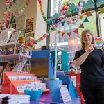 PRIDE PREP: Heather Allen, manager of the independent craft/gift shop Craftland on Westminster Street in Providence, which not only supports the transgender community but also sells work by transgender artists, prepares the shop for Pride Week.  PBN PHOTO/MICHAEL SALERNO