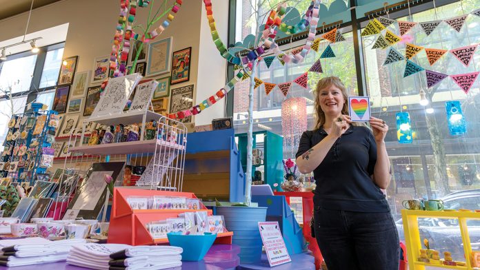 PRIDE PREP: Heather Allen, manager of the independent craft/gift shop Craftland on Westminster Street in Providence, which not only supports the transgender community but also sells work by transgender artists, prepares the shop for Pride Week.  PBN PHOTO/MICHAEL SALERNO