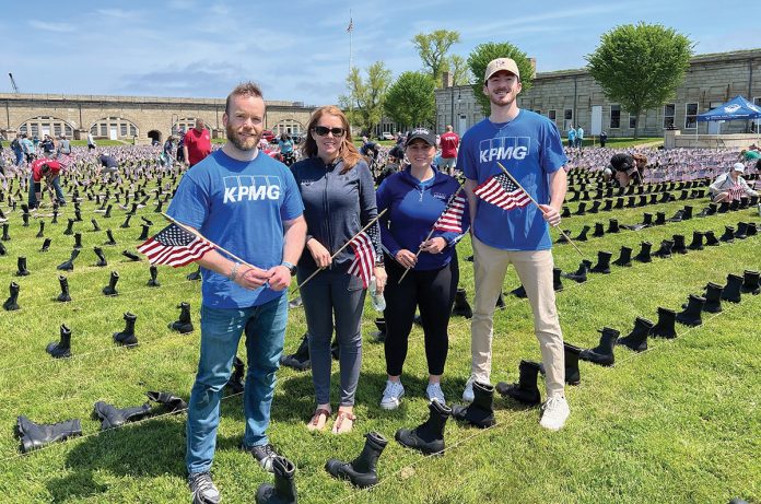 REMEMBERING VETERANS: KPMG LLP employees help set up the “Boots on the Ground” display with Wounded Warriors at Fort Adams State Park in Newport.  COURTESY KPMG LLP