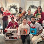 GIFT GIVING: Onward We Learn employees receive raffle gifts during the organization’s holiday party.  COURTESY ONWARD WE LEARN