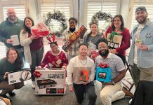 GIFT GIVING: Onward We Learn employees receive raffle gifts during the organization’s holiday party.  COURTESY ONWARD WE LEARN