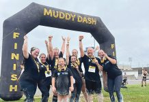 DASH TO THE FINISH: South County Smiles staffers celebrate at the finish line of the 2024 Muddy Dash Race.  COURTESY SOUTH COUNTY SMILES