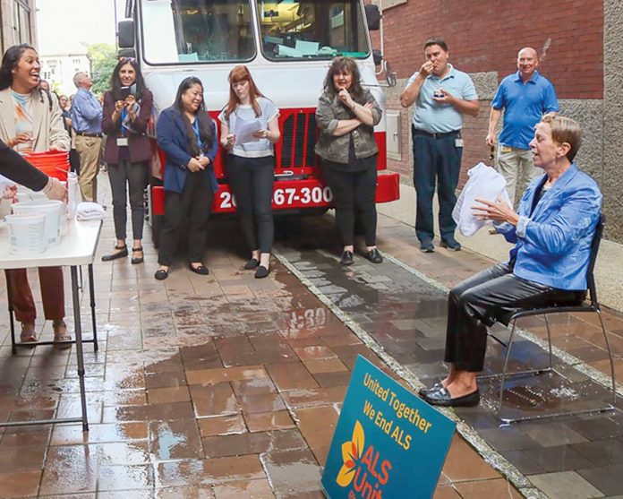 SPLASH DOWN: R.I. Housing and Mortgage Finance Corp. staff doused CEO and Executive Director Carol Ventura with water to help raise more than $1,000 in donations for the ALS United RI.  COURTESY R.I. HOUSING AND MORTGAGE FINANCE CORP. 