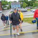 GOING ON FOOT: Sonia Rodriguez, holding the green umbrella, of Smithfield leads the “Walk with a Doc” at South Main Street in Providence in June. Although there was no doctor on this particular walk and it was threatening to rain, the participants forged ahead because the health-related program has also become a social exercise.  PBN PHOTO/MICHAEL SALERNO