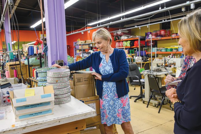 PRODUCT ASSESSMENT: Alice Nichols, left, founder and owner, and Donna Bodell, vice president and designer, look over some of the products on the factory floor at pet supply manufacturer Up Country in East Providence. PBN PHOTO/MICHAEL SALERNO