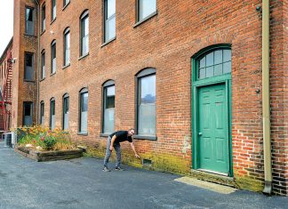 ON THE MARK: Richard Grundy, CEO and president of AVTECH Software Inc., indicates the level of floodwater at Cutler Mill in Warren, where AVTECH’s offices are located.  PBN PHOTO/MICHAEL SALERNO