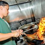 HOT SPOT: Chef Subat Dilmurat, owner of Jahunger LLC, a Uyghur restaurant in Providence, prepares one of his signature dishes, Jahunger Noodles.  PBN PHOTO/MICHAEL SALERNO