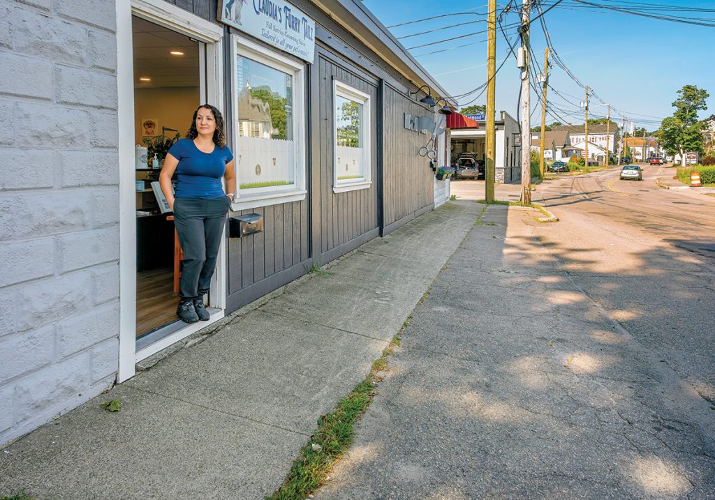 HIDDEN HAZARD: Claudia Conley, owner of Claudia’s Furry Tailz Pet Spa LLC, stands in the doorway at the spa on Market Street on a dry summer day. She says she lost two days of business last winter because of flooding. PBN PHOTO/MICHAEL SALERNO