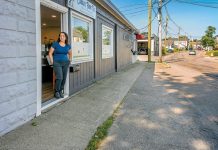 HIDDEN HAZARD: Claudia Conley, owner of Claudia’s Furry Tailz Pet Spa LLC, stands in the doorway at the spa on Market Street on a dry summer day. She says she lost two days of business last winter because of flooding. PBN PHOTO/MICHAEL SALERNO
