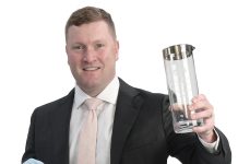 the prop Timothy Grimes holds a Newport-Bermuda regatta hat and a trophy for the Ida Lewis Distance Race, symbolizing his love for sailing.