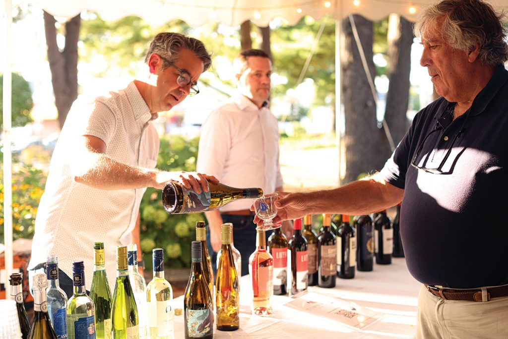 FRESH POUR: A sommelier pours a glass for a guest at the 2024 Summer Soiree food and wine tasting event at the Little Sisters of the Poor residence in Pawtucket. This year’s Soiree is set for Aug. 13. COURTESY 9TEN PHOTOGRAPHY/LAURA KILGUS